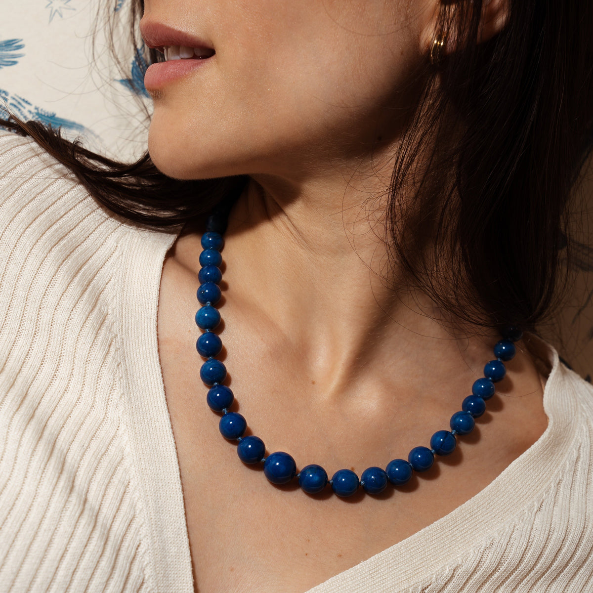Woman wearing lapis beaded necklace