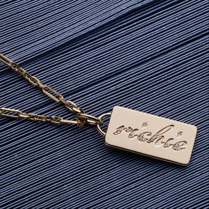 Custom solid gold cast word with diamond charm on a solid gold chain