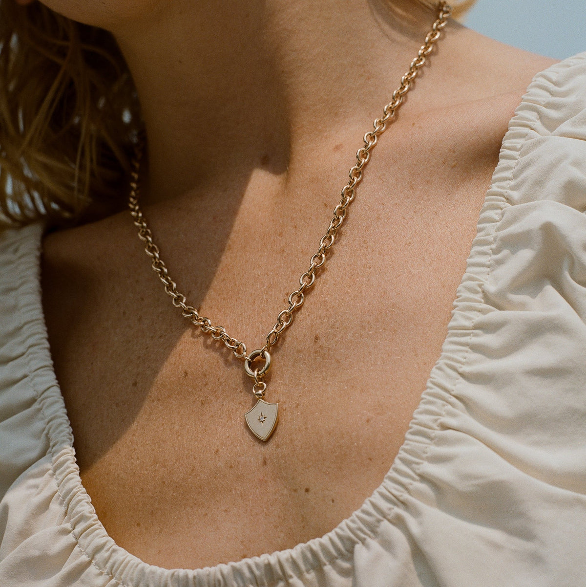 A close-up of a gold chain with a charm clip that can be used to display your fewer finer personalized charms