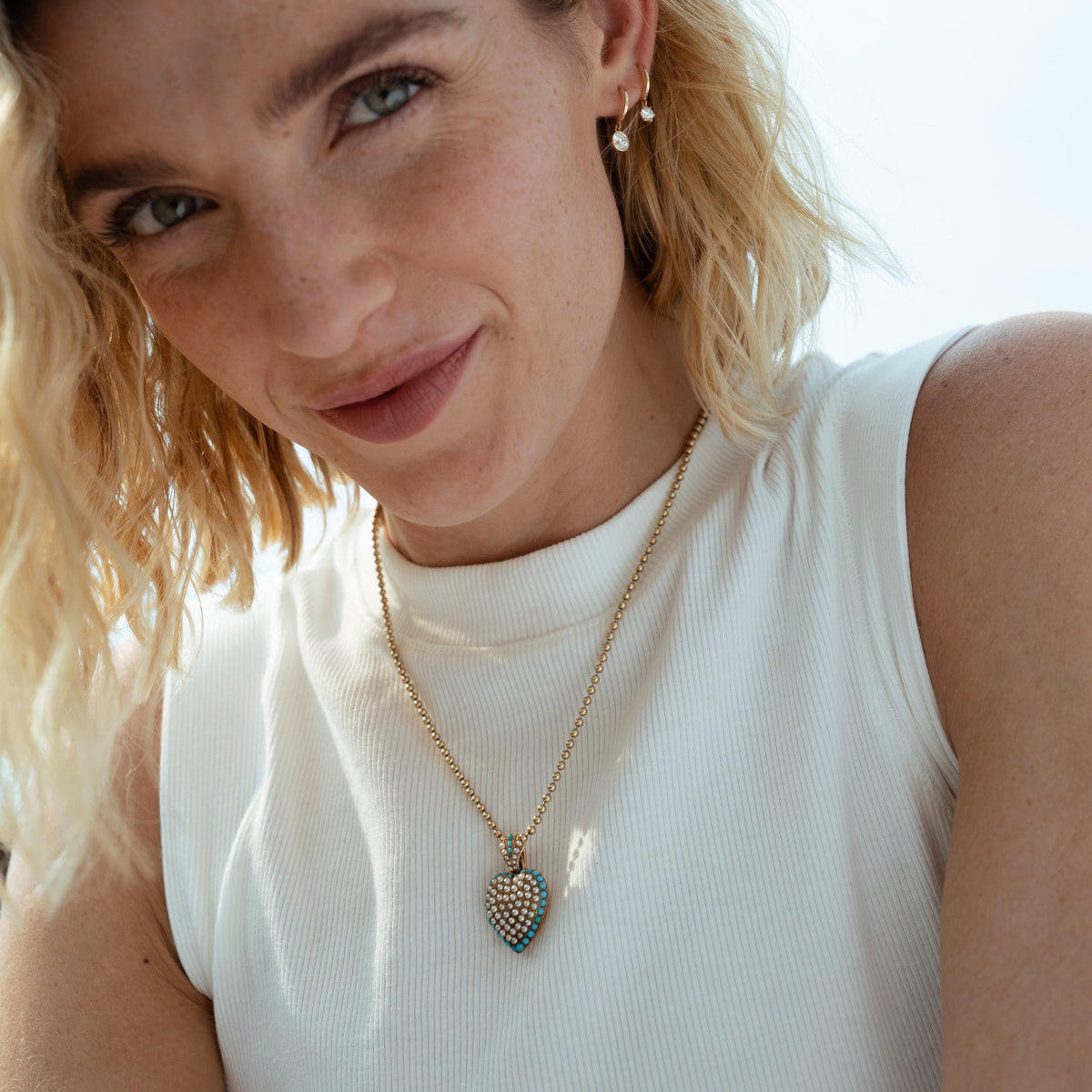 A vintage puffy heart charm with pearl and turquoise