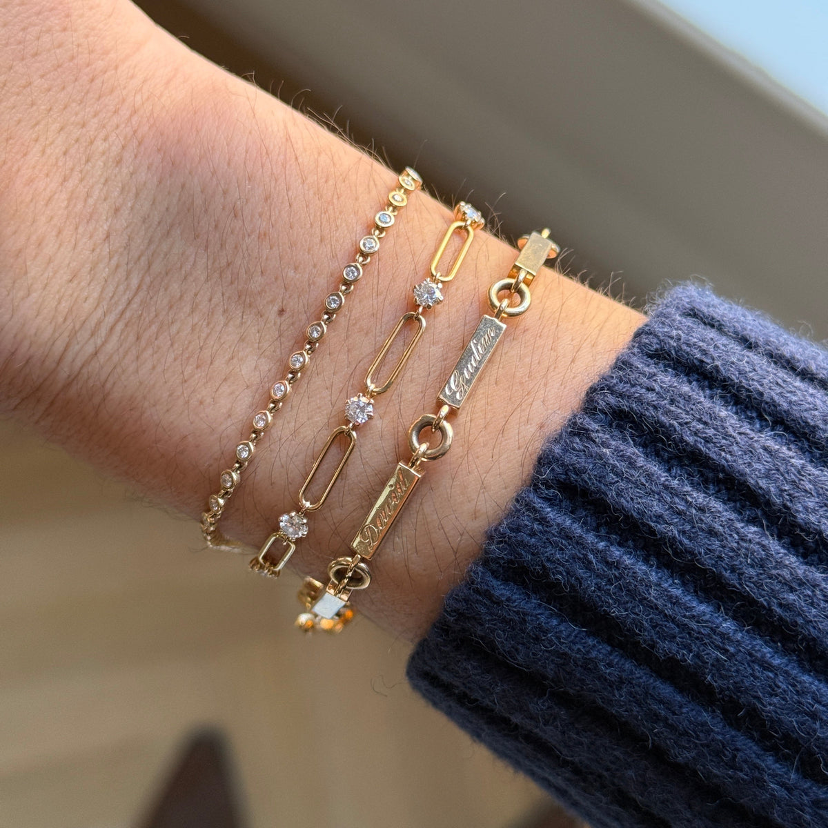The garden party bracelet stacked with the 1.5mm ping pong bracelet and the family bracelet hand engraved