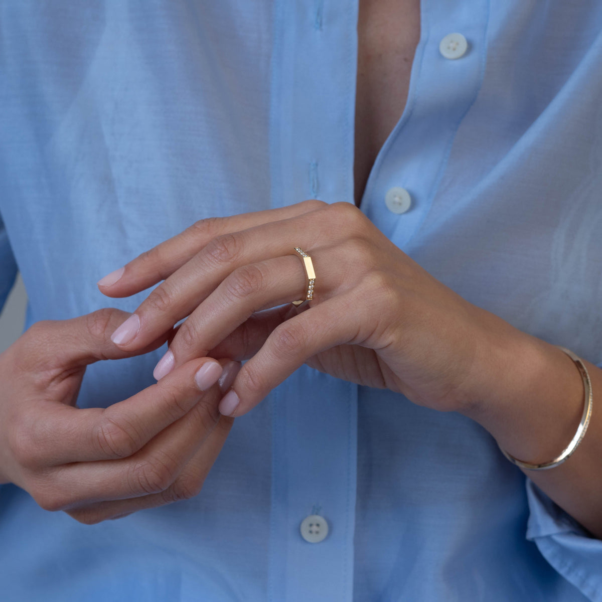 Close-up of a woman's hand wearing two family rings with personal hand engraving and diamonds