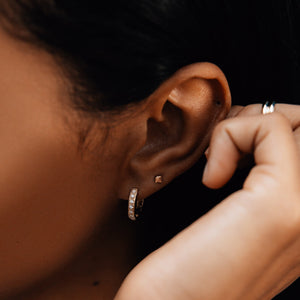 Model wearing 14k gold diamond huggies