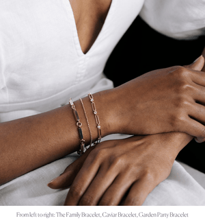 Model wearing 14k solid gold bar link engravable bracelet stacked with Caviar Bracelet and Garden Party Bracelet