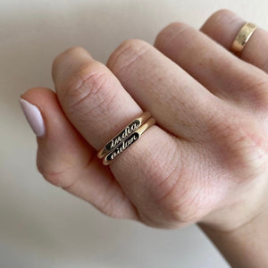 Model wearing two custom engravable gold signet ring