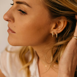 Model wearing 14k gold diamond huggies