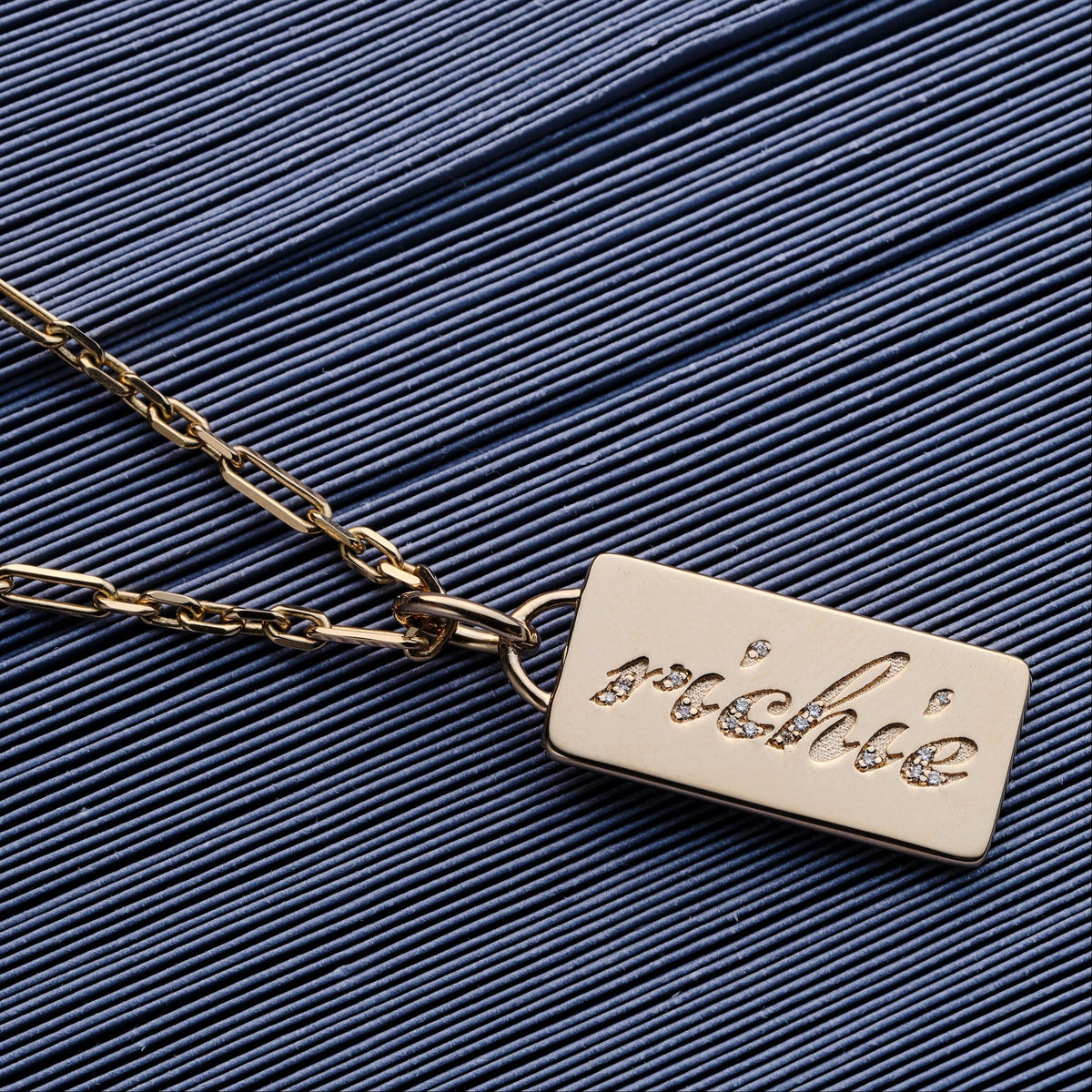 Custom solid gold cast word with diamond charm on a solid gold chain