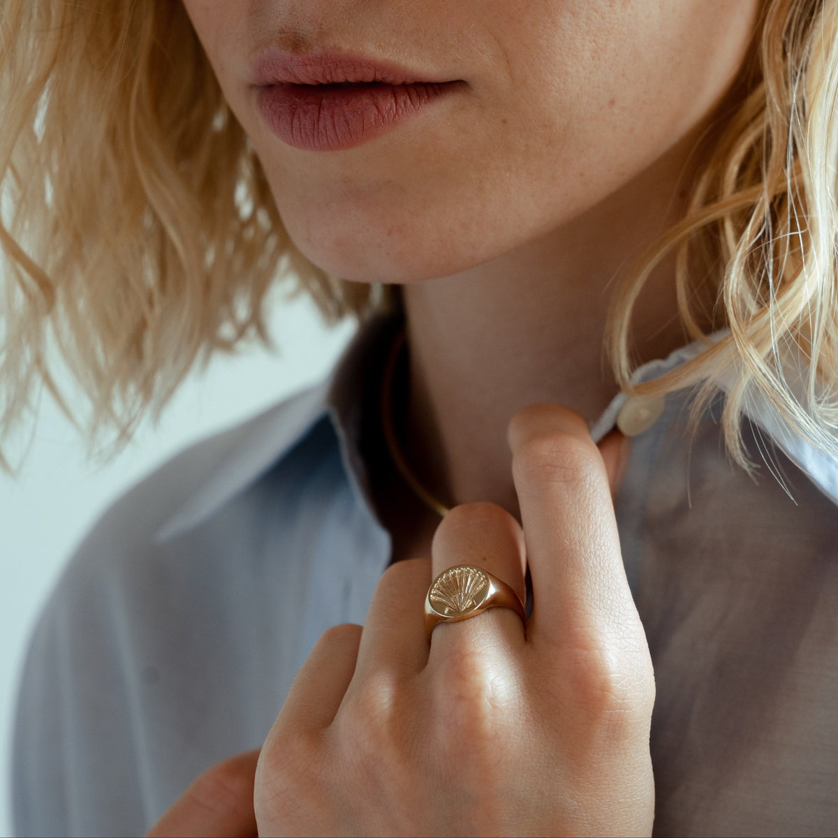 A close-up of the solid gold round signet ring with a custom hand engraved scallop shell, personalize this piece with any artwork to represent yourself