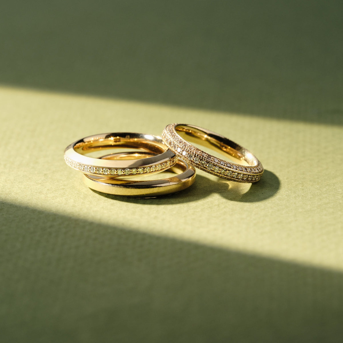 a stack of 3 solid gold rings with diamonds around the band meant for wedding bands or stacking rings 