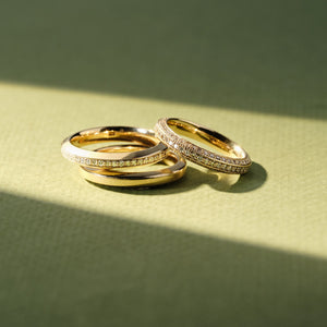 a stack of 3 solid gold rings with diamonds around the band meant for wedding bands or stacking rings 