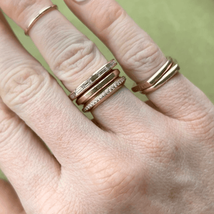 Model wearing 14k gold band with baguette diamonds across the entire band stacked with Signature Eternity Ring and Signature Band