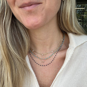 Model wearing 14k gold lapis and turquoise beaded necklaces