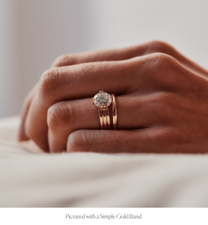 Model wearing the 14k gold triple band design engagement ring with a round diamond and stacked with the Simple Gold Band