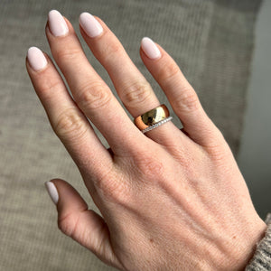 Model wearing 14k gold thick engravable cigar band ring stacked with a diamond eternity ring