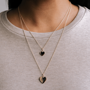 Model wearing two sizes of the 14k solid gold engravable heart charms 