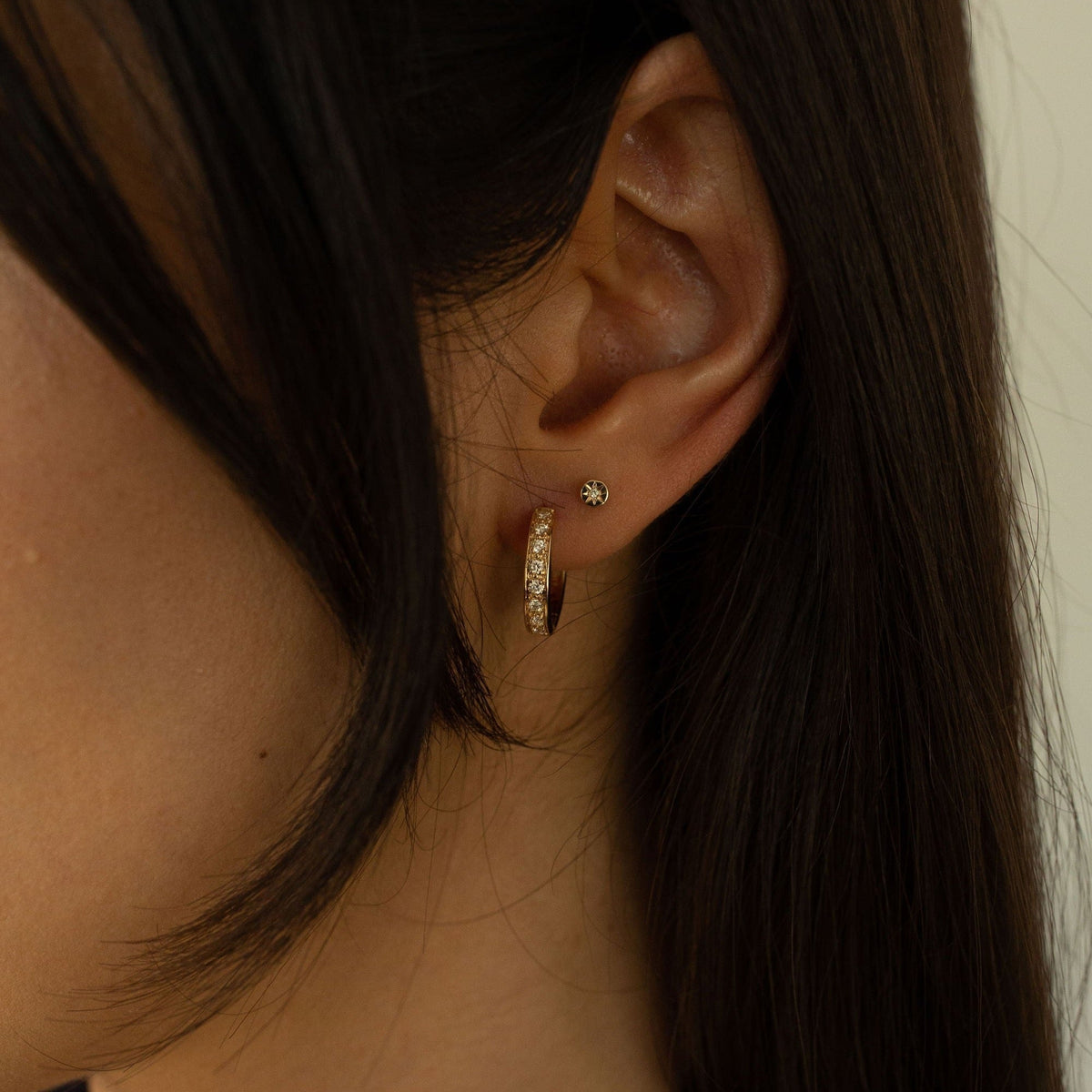 Model wearing 14k gold diamond huggies