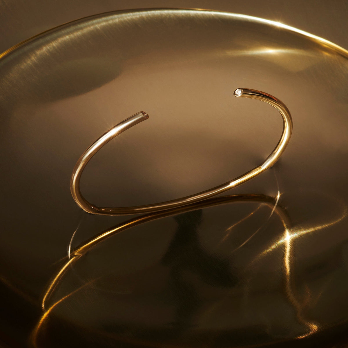 14k gold rounded cuff bracelet with diamonds at each end