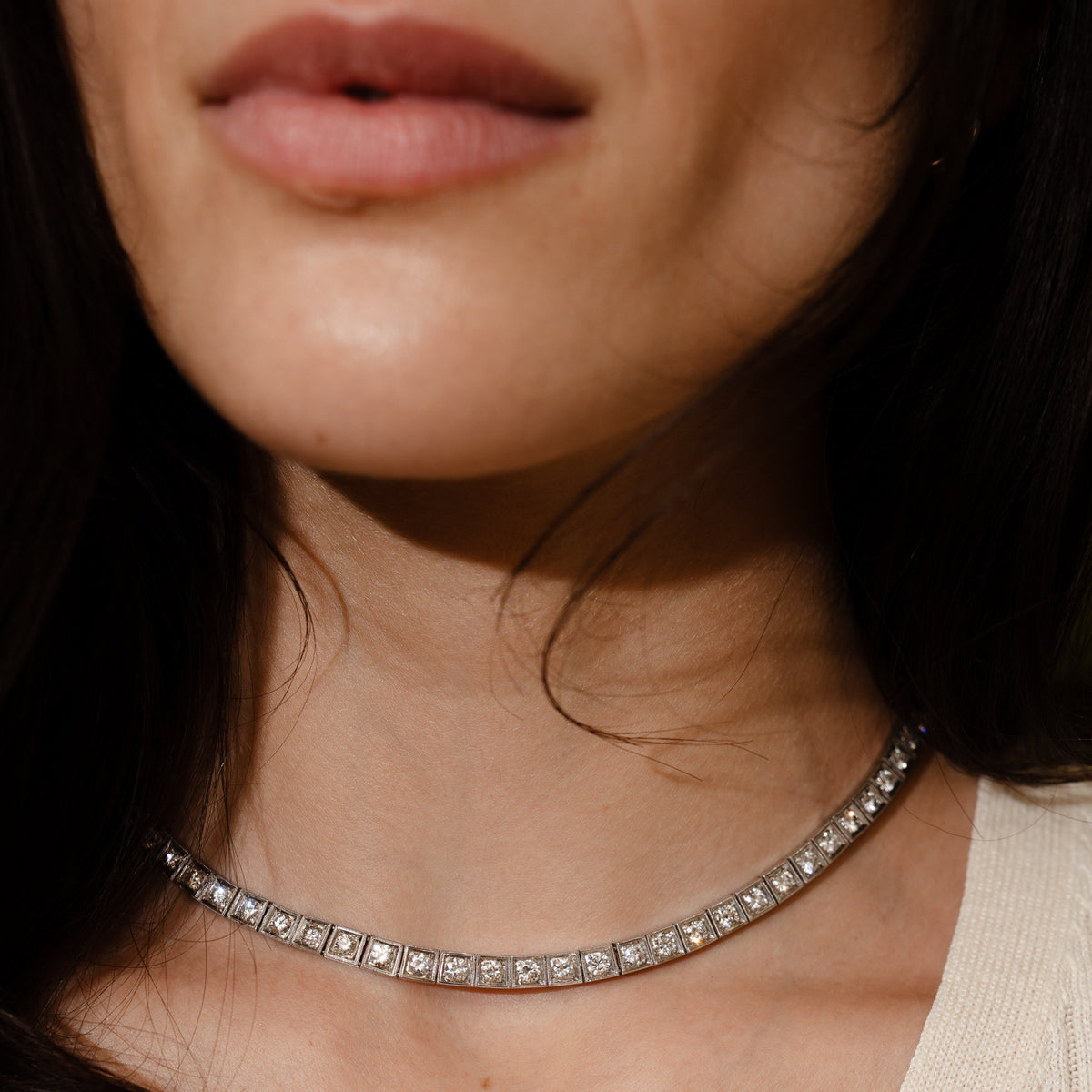 close-up of a vintage platinum diamond tennis necklace with hand engraving details