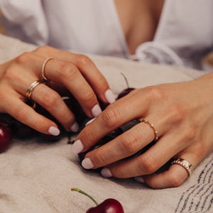 Model wearing the 14k gold ring with fig leaf imprints across the band on pinky finger