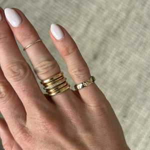 Model wearing 14k gold ring with Ginkgo leaf imprints across the band on pinky finger