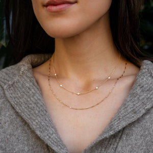 Model wearing 14k gold chain with diamonds layered with Pins and Needles Chain