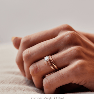 Model wearing the 14k gold double band knot design engagement ring stacked with the Simple Gold Band