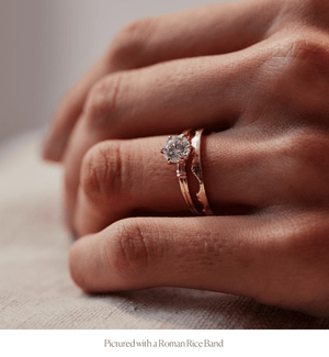 Model wearing the 14k gold double band knot design engagement ring stacked with the Roman Rice Band