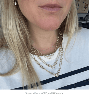 Model wearing chunky mixed link charm necklace in various sizes