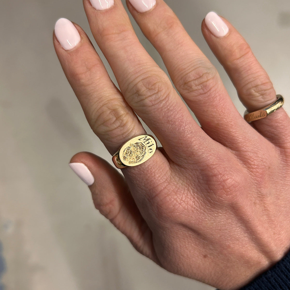 Model wearing 14k solid gold oval signet ring with custom hand engraved pet portrait