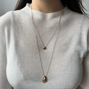 Model wearing 14k solid gold pebble necklace stacked with Worry Stone Necklace