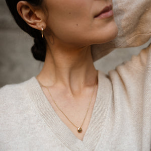 Model wearing 14k solid gold pebble necklace