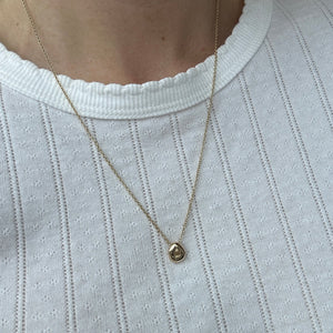 Model wearing 14k solid gold pebble necklace