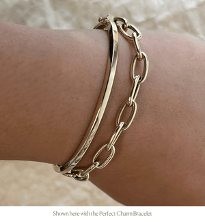 Model wearing 14k gold solid bangle with another bracelet