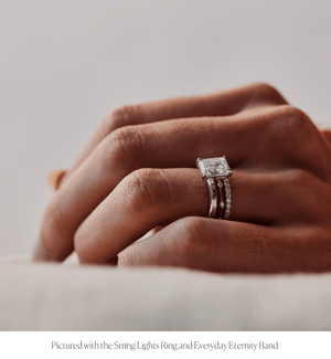 Model wearing the 14k white gold solitaire engagement ring with an emerald cut diamond stacked with the String Lights Ring and Everyday Eternity Band