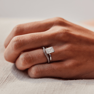 Model wearing the 14k white gold solitaire engagement ring with an emerald cut diamond