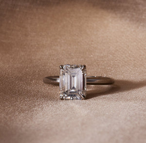 14k white gold solitaire engagement ring with an emerald cut diamond