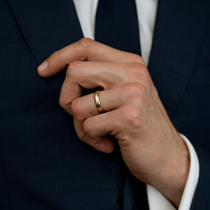 Male model wearing the unisex 14k solid gold band engravable band