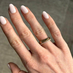 Model wearing the 14k solid gold engravable straight signet ring stacked with an eternity band