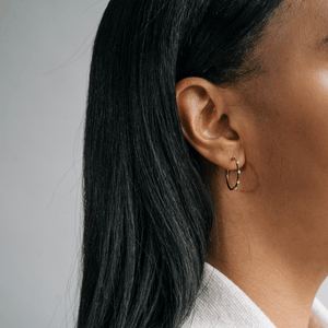 Model wearing 14k gold hoops with diamonds