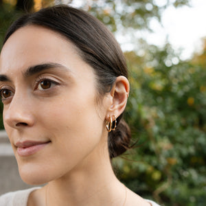 Model wearing 14k gold hoops with diamonds stacked with Signature Hoops