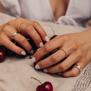 Model wearing a thin 14k gold ring with diamonds