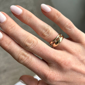 Model wearing a thin 14k gold ring with diamonds stacked with two gold rings