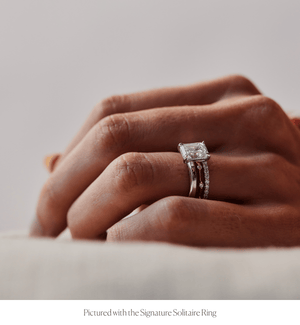 Model wearing a thin 14k gold ring with diamonds stacked with an engagement ring