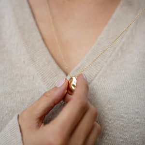 Model wearing 14k solid gold textured worry stone necklace 