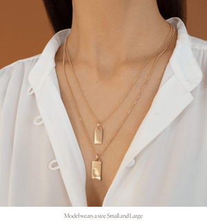 Model wearing the small and large size of the 14k solid gold engravable rectangle charm 