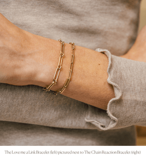 Model wearing the 14k semi-hollow gold link chain charm bracelet stacked with the Chain Reaction Bracelet