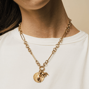 Model wearing chunky mixed link 14k gold charm necklace with charms