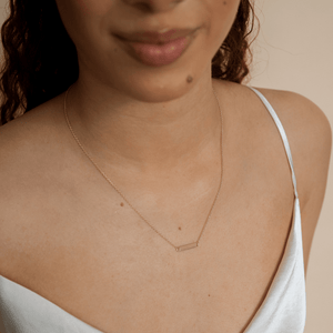 Model wearing 14k gold engravable nameplate necklace 