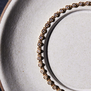 A close-up detail of the 14k gold tennis bracelet with bezel set diamond links