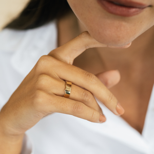 Model wearing the unisex 14k solid gold scalloped edge engravable band